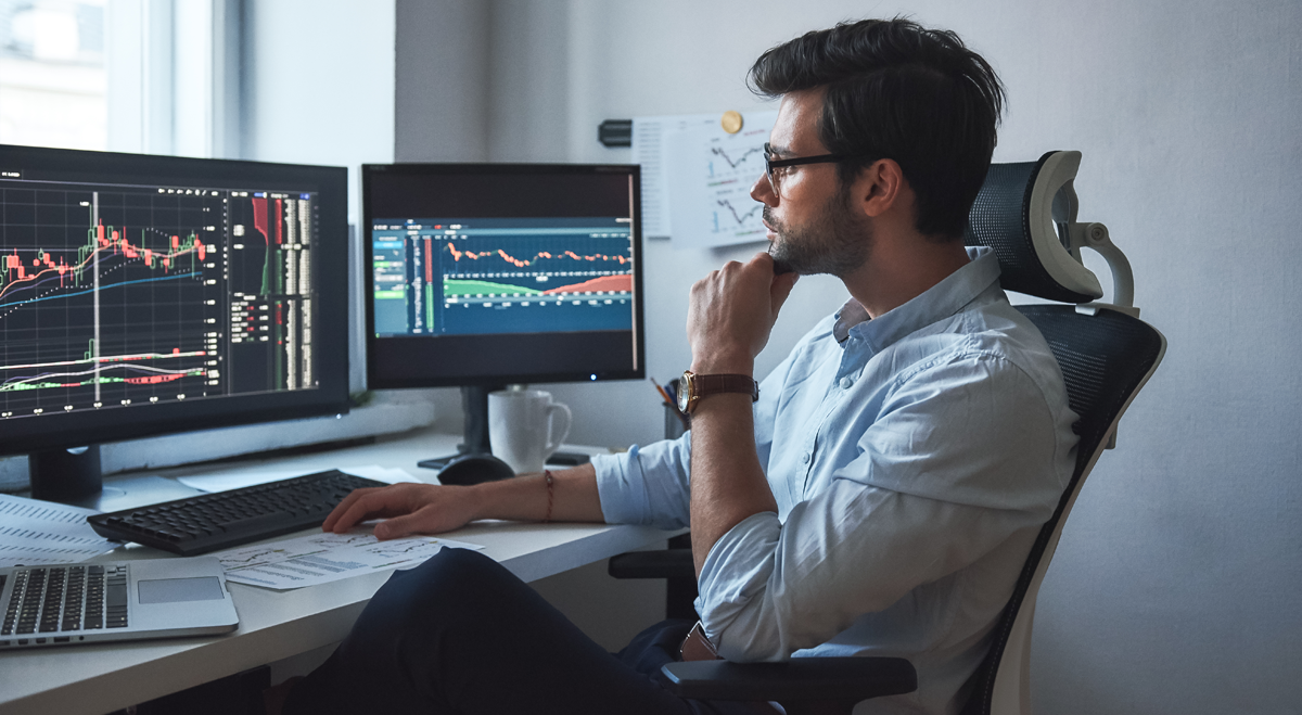 Trader sitting in front of screens